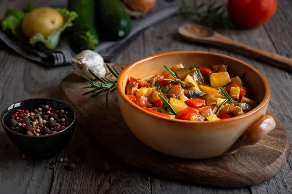 Chopped cooked vegetables on dark wood. ratatouille with zucchini, bell pepper and eggplant