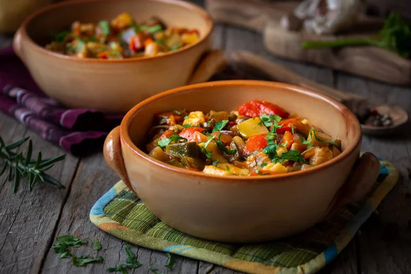 Chopped cooked vegetables on dark wood. ratatouille with zucchini, bell pepper and eggplant