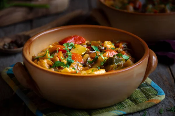 Chopped cooked vegetables on dark wood. ratatouille with zucchini, bell pepper and eggplant