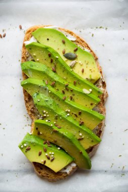 Beyaz arka planda avokado sandviçi, sağlıklı vejetaryen atıştırmalığı.