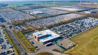 Ketzin, Brandenburg/Germany - 26.03,2020: The premises of the company Mosolf in Ketzin Brandenburg with thousands of vehicles stored on the site photographed from the air. clipart