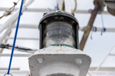 Eski bir konum ışığı berrak cam, çizik, pas izleri ve kalın beyaz boya ile.