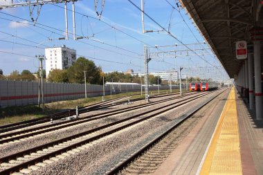 Tren istasyonu metrosu. Demiryolu platformu. Uzakta demiryolu ve iki tren bekliyor.