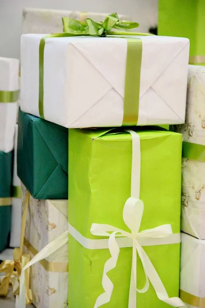 Viele Schachteln mit Geschenken in den Farben grün, beige und gold. Großer Stapel Weihnachtsgeschenke — Stockfoto