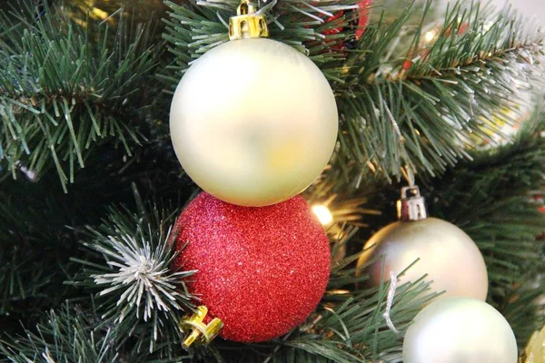 Sosnowy świąteczny wystrój. sztuczny świerk ozdobiony girlandami czerwone i złote szklane matowe kulki. — Zdjęcie stockowe