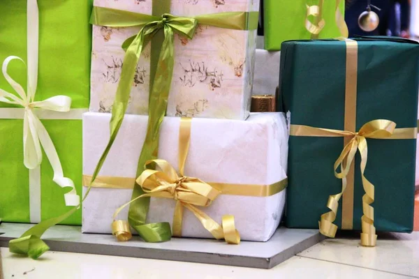 many Packed boxes with gifts in green, beige and gold colors. large stack of Christmas presents. christmas holidays decor