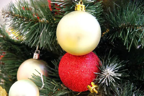 Heldere kerstboom ballen. Kerst groene boom en glazen speelgoed gouden en rode ballen decoratie — Stockfoto