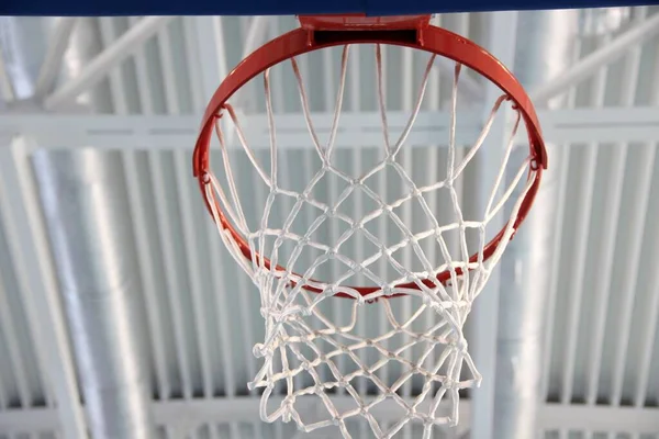 Üres piros kosárlabda gyűrű és fehér háló beltéri edzőteremben — Stock Fotó