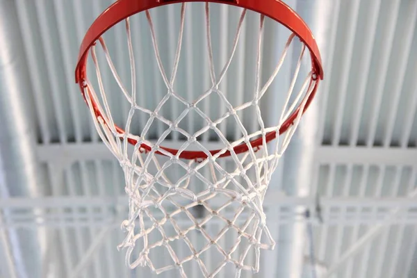 Aro de baloncesto rojo vacío y red blanca en el gimnasio interior —  Fotos de Stock