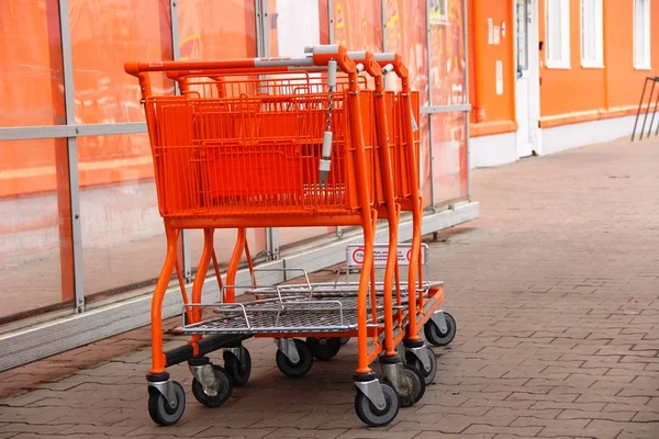 Carrinhos de compras em uma fileira, compras em tons de laranja — Fotografia de Stock