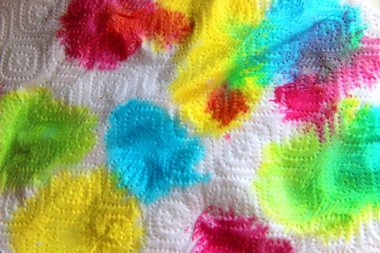 Beyaz kağıt peçetedeki çok renkli parlak boya lekeleri. soyut arkaplan