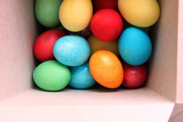 Beyaz kare bir kutuda bir sürü renkli Paskalya yumurtası. Paskalya hazırlıkları. Yumurta boyamak. Boyalı yumurta, renkli boya. — Stok fotoğraf