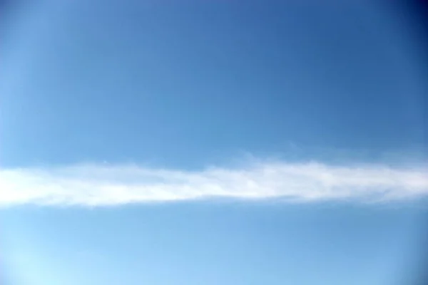 Bright blue sky and a strip of clouds horizontally. spring, blue sky with a thin strip of clouds — 스톡 사진