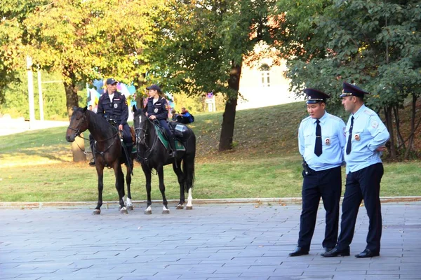 Moskova, Rusya - Eylül 2019: Atlar ve piyadeler tetikte. İki polis ve iki ayaklı polis memuru şehrin sokaklarını koruyor.