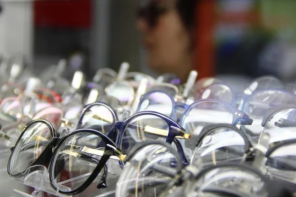 Un montón de gafas para mejorar la visión en una fila. escaparate de óptica — Foto de Stock