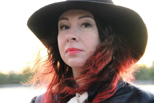 빨간 머리에 챙 이 넓은 전형적 인 검은 모자를 쓰고 있는 여자. 스스로 고립된 후에. — 스톡 사진