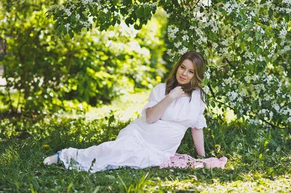 Mujer embarazada descansando a la sombra de un jardín floreciente 8258 . —  Fotos de Stock