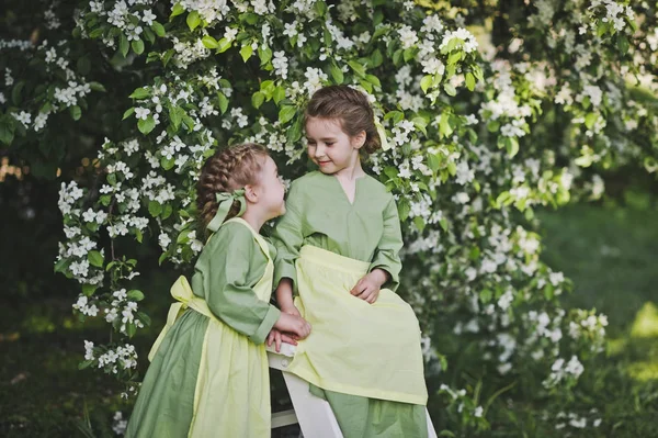 Girlfriend in vintage costumes of maids playing in the spring ga — Stock Photo, Image