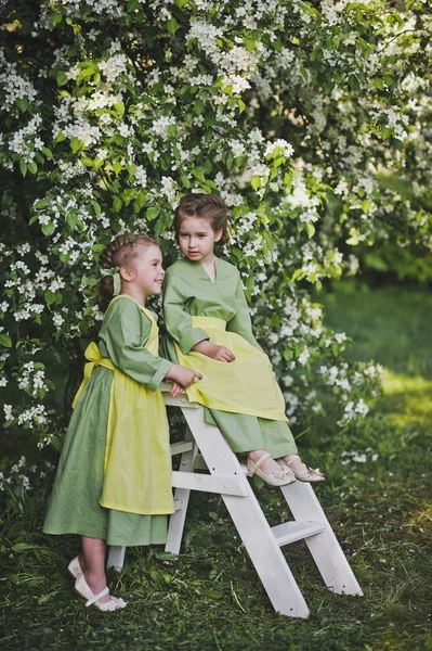 Namorada em trajes vintage de empregadas domésticas jogando na primavera ga — Fotografia de Stock