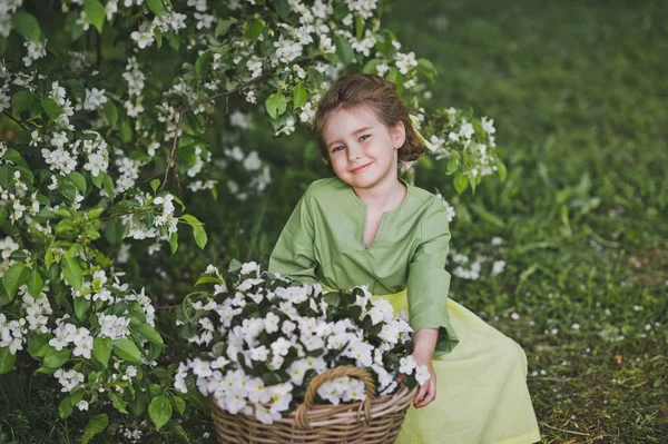 Dziecko siedzi w pobliżu duży kosz kwiatów 8313. — Zdjęcie stockowe
