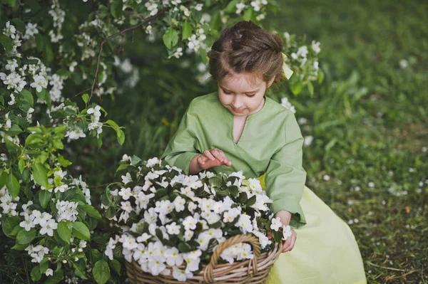 Dziecko siedzi w pobliżu duży kosz kwiatów 8315. — Zdjęcie stockowe