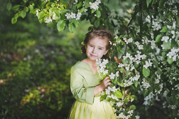 Portret dziecka stojący w pobliżu gałęzie wiśni blo — Zdjęcie stockowe