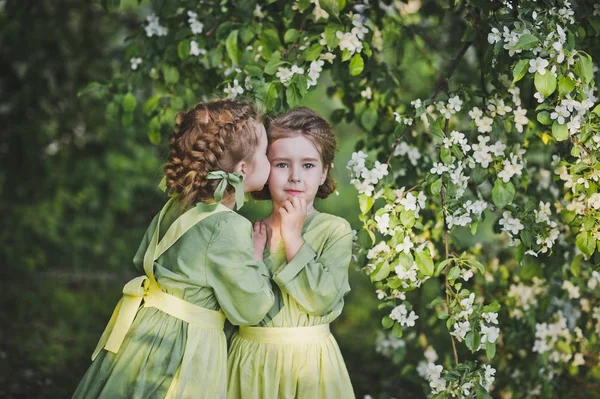 Los niños se abrazan en el fondo del jardín de primavera — Foto de Stock
