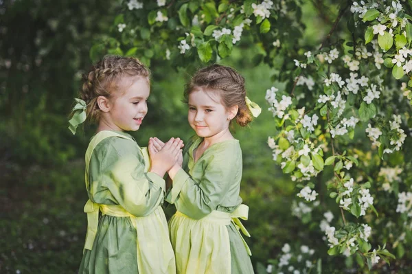 Los niños se abrazan en el fondo del jardín de primavera —  Fotos de Stock