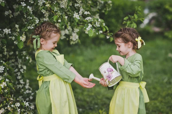 Bambini che giocano con un piccolo annaffiatoio in giardino 8363 . — Foto Stock