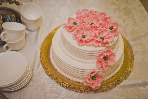 En stor kaka gjord av beige grädde dekorerad med rosa blommor 8496. — Stockfoto