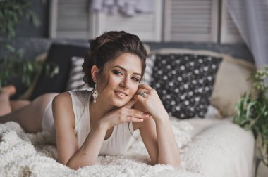 Güzel esmer pencerenin 8734 yatakta reclines.