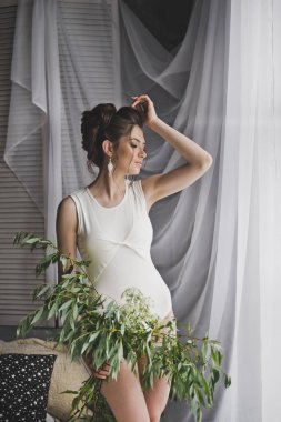 Sıkı bir beyaz bluz ayakta penceredeki 8739 gülümseyen kız