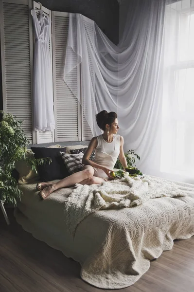 Girl in blouse luxuriating in bed with a huge window 8730. — Stock Photo, Image