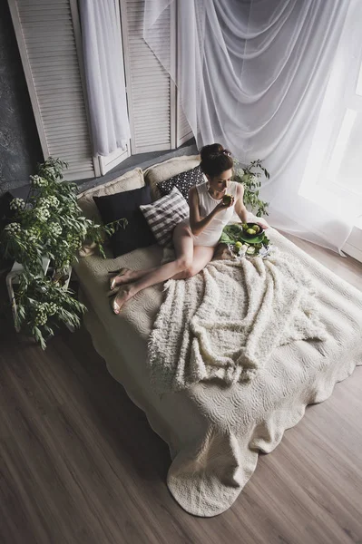 Красивая брюнетка лежит на кровати у окна 8731 . — стоковое фото