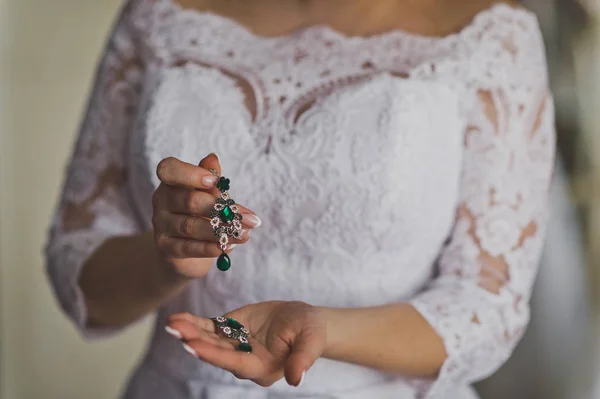 Vrouwelijke hand met een prachtige groene Oorhangers 8831. — Stockfoto