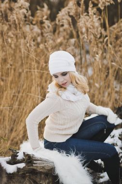 Kız s ile kaplı düşmüş bir ağaç gövde dinleniyor