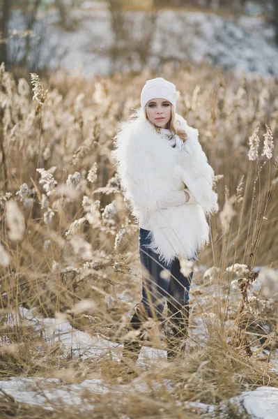 Retrato de uma menina em um casaco de pele branca no meio da cana — Fotografia de Stock
