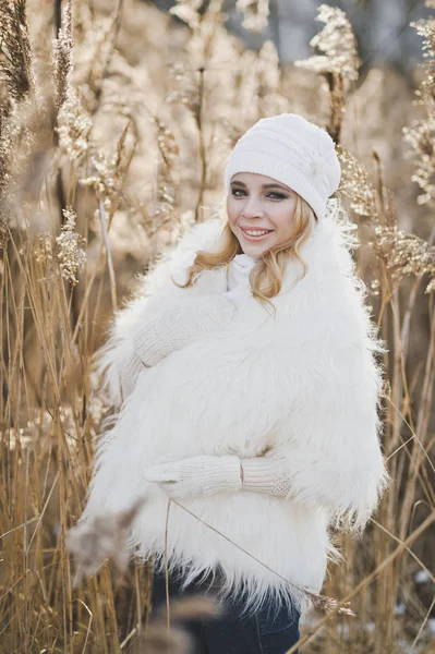 在芦苇中间的一个白色毛皮大衣的女孩的肖像 — 图库照片