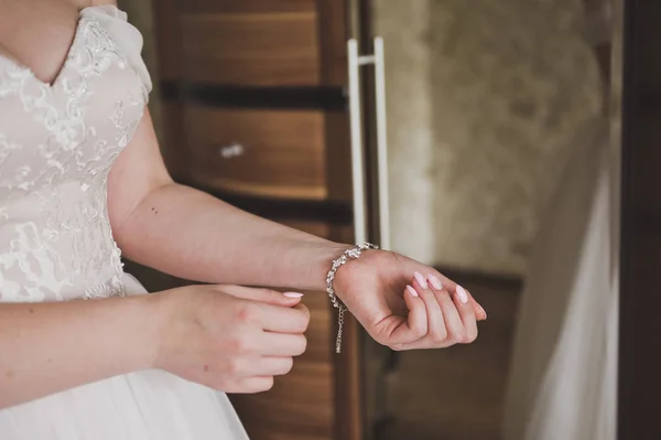 La mariée boutonnant le bracelet sur son bras 9246 . — Photo