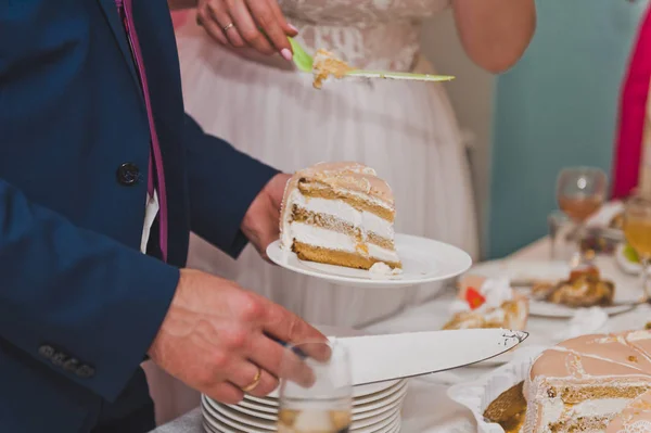 O jovem marido e mulher para dividir pedaços de bolo para tratá-lo — Fotografia de Stock