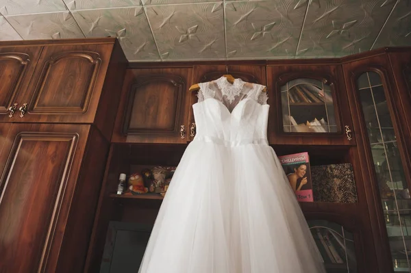 The brides wedding dress hanging on a hanger in the room 9366. — Stock Photo, Image