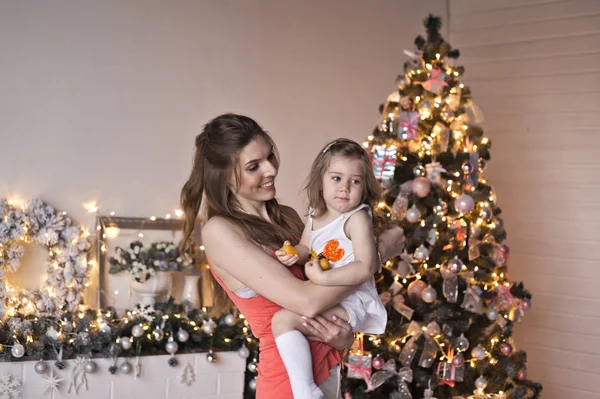 A menina vira o bebê em torno da brilhante árvore de Natal 946 — Fotografia de Stock