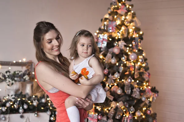La niña gira al bebé alrededor del brillante árbol de Navidad 946 — Foto de Stock