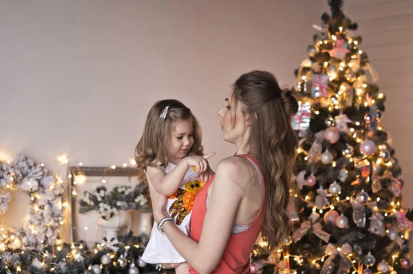 Мама обнимает дочь рождественскими украшениями. — стоковое фото