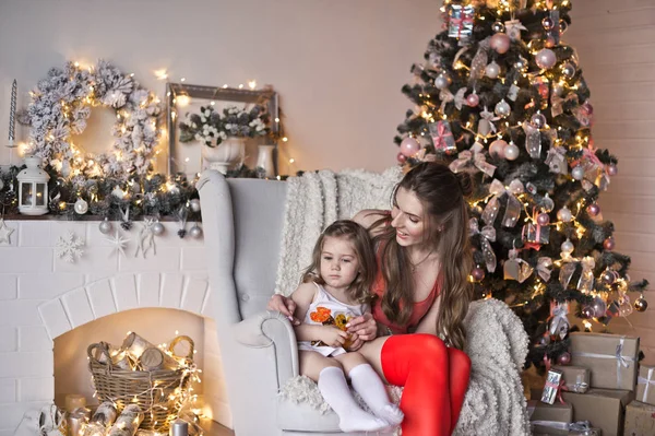 Moeder en dochter op de achtergrond van fonkelende kerst gar — Stockfoto