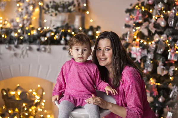 La niña al lado de su madre, rodeada de ligh de Navidad — Foto de Stock