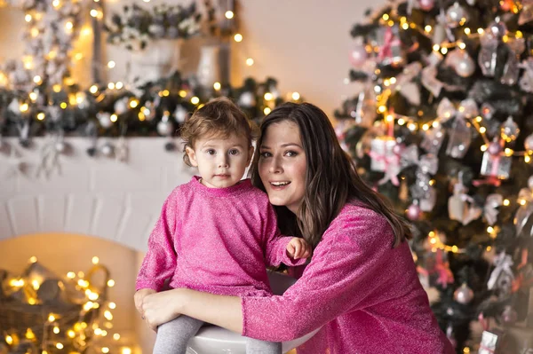 Das kleine Mädchen neben ihrer Mutter, umgeben von Weihnachtslichtern — Stockfoto