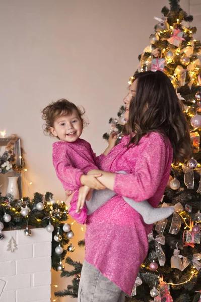 Chica jugando con la madre en el fondo de la decoración de Navidad — Foto de Stock