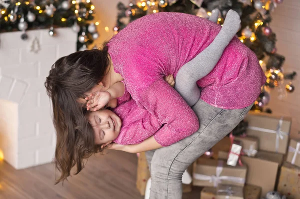 クリスマス装飾の背景に母と遊ぶ女の子 — ストック写真