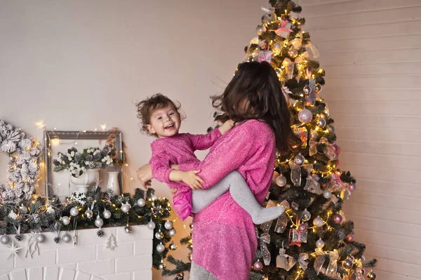 女孩在圣诞节 decorati 的背景下与母亲玩耍 — 图库照片